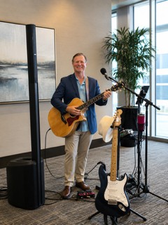 Michael McCormick set up for an indoor corporate event with acoustic and electric guitars