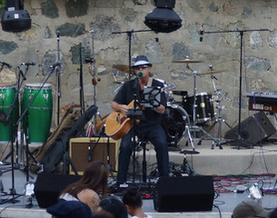 Michael McCormick playing an outdoor concert stage for a seated crowd