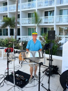 Michael McCormick playing steel drum at a resort patio with percussion and PA