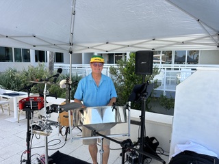 Michael McCormick playing steel drum under a white tent at a resort event